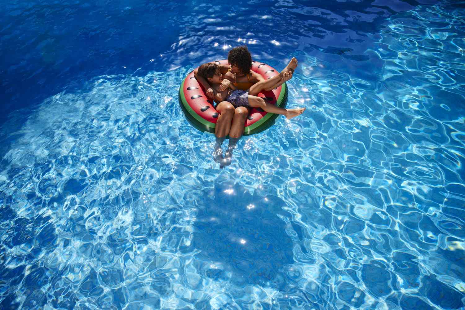 Parent with child in a safely fenced pool